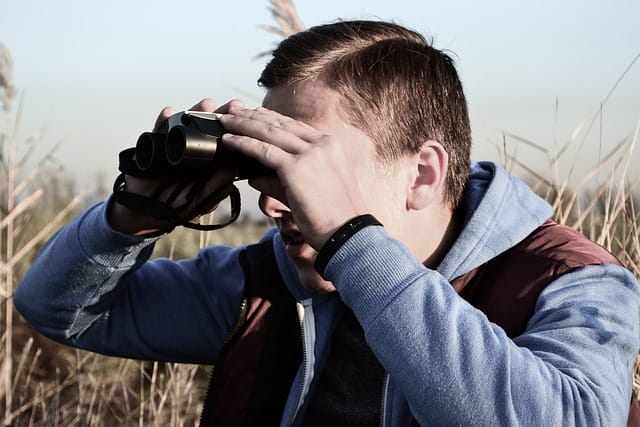 man looking through binoculars