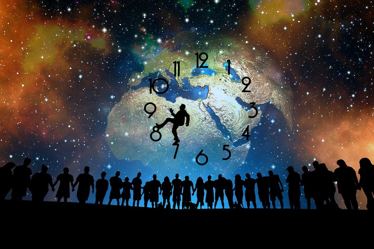 People looking at man climbing clock on globe